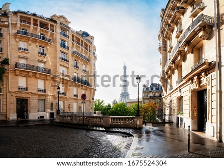 cosy Paris street with view on the famous Eiffel Tower on a cloudy summer day, Paris France, toned Royalty-Free Stock Photo #1675524304
