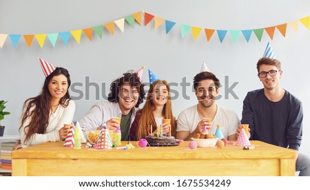 Happy Birthday party. A group of friends with a cake wishes the girl a happy birthday