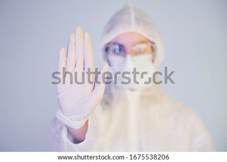 Stop the virus sign. Portrait of female doctor scientist in lab coat, defensive eyewear and mask.