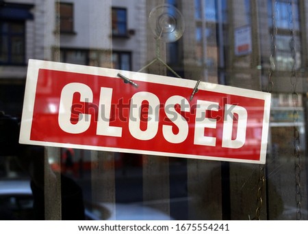 Closed sign a in shop window with blurred background reflections