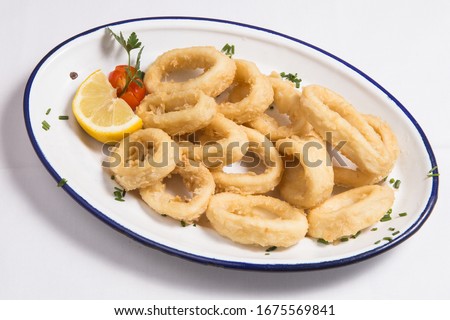 Fried squids or octopus (calamari) with sauce isolated on white background
