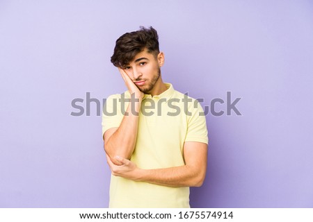 Young arabian man isolated on a purple background who is bored, fatigued and need a relax day.
