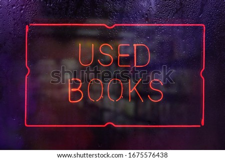 Neon Used Books Sign in Rainy Window