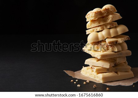 pile of white chocolate on black background with free text space