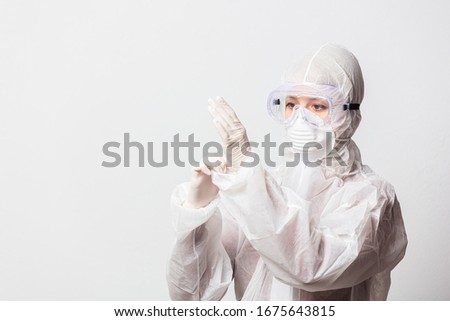 young doctor in protection suit and glasses with mask on white background