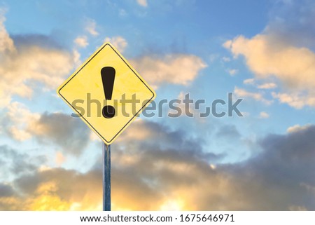 Exclamation mark on the road yellow sign. Against the sky. Concept Warning, danger.
