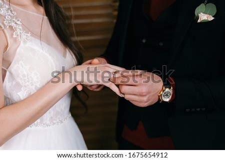 the groom puts the ring on the bride at the wedding ceremony