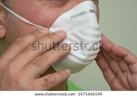 white disposable face mask on a man's face ,Coronavirus mask  (COVID-19) Royalty-Free Stock Photo #1675666540