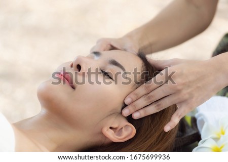 Beautiful young asian woman enjoying massage at outdoors in spa salon, day time.