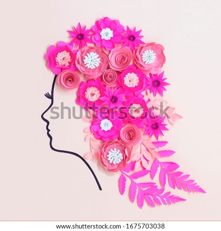 Stylized silhouette of female head painted with felt-tip pen with paper flowers instead of hairstyle. Real volumetric handmade paper objects. Paper craft and art. Greeting card for Women's Day