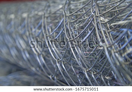 Rolls of chain link fence wire mesh placed them in storage awaiting for sell or disposal wire fence. seamless chain link fence. industrial fence Royalty-Free Stock Photo #1675715011