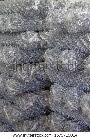 Rolls of chain link fence wire mesh placed them in storage awaiting for sell or disposal wire fence. seamless chain link fence. industrial fence Royalty-Free Stock Photo #1675715014