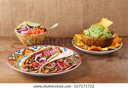 Beef meat and vegetables Mexican tacos with guacamole nachos