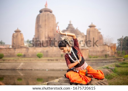 Beautiful Indian classical odissi dancer posing at Brahmesvara Temple in bhubaneswar, odisha, India