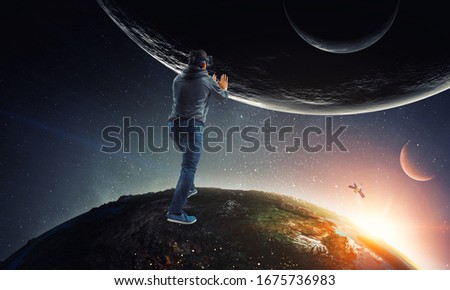 Young businessman in VR glasses rolling the Earth