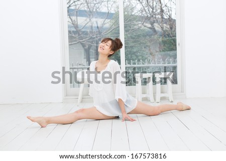 Attractive asian woman doing yoga exercise in the room 