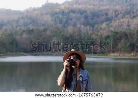 Young traveler woman taking pictures with a camera in the holiday. Travel hiking. Travel and wanderlust concept.