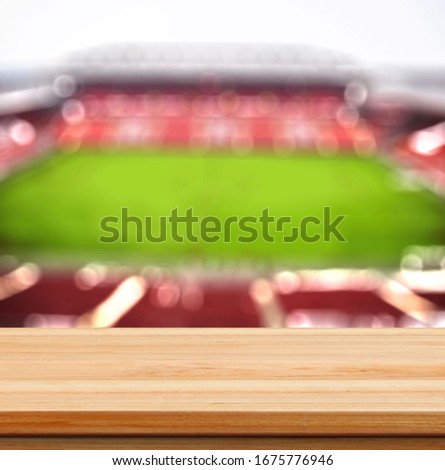 wooden top table with football stadium blurred background