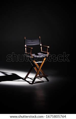 Directors chair stands in the beam of light. Space for text.
Vacant chair. The concept of selection and casting. Shadow and light. Royalty-Free Stock Photo #1675805764