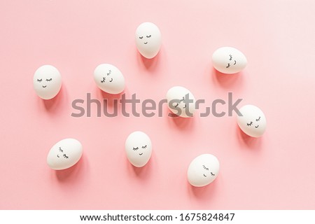 Creative easter eggs with cute face and sleepy eyes on pastel pink background. Happy Easter concept. Flat lay, top view, mockup, template, overhead, copy space