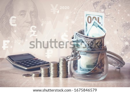 Coins Stack, calculator, dollar bills in glass jar, virtual hologram, earth, stat, graph,currency icons different countries. Savings money,income Investment ideas, management.Business Growth concept