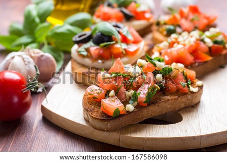 Italian Appetizer Bruschetta with roasted tomatoes, mozzarella cheese, garlic and herbs  Royalty-Free Stock Photo #167586098