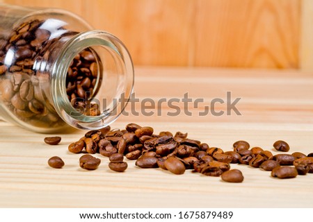 Coffee poured into a glass cup standing on a wooden surface. Background for coffee and coffee drinks.
