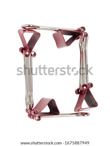 Numeral 0 red binder clips alphabet. Office metal foldback braces. Metal binder clips isolated on white background