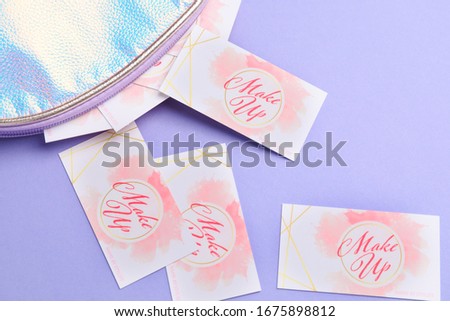 Bag with business cards of makeup artist on color background