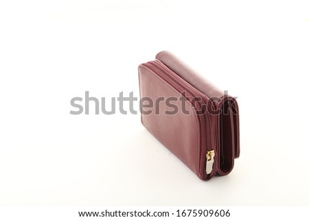 New burgundy women's leather wallet with banknote and credit card isolated in white background.