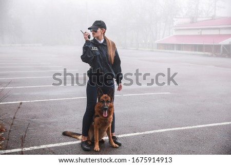 Female police officer with dog patrolling city street
