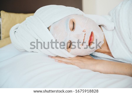 Portrait of young woman sleeping on bed while applying facial mask on her face. Conceptual of young woman lifestyle in her private room.