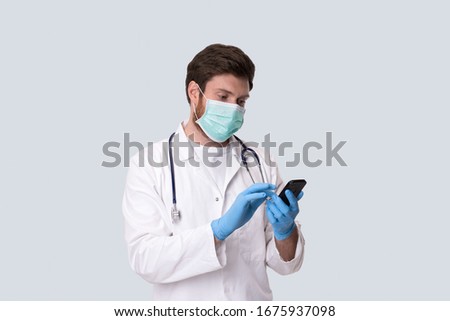 Man Doctor Wearing Medical Mask Using Phone. Virus Concept. Medical Worker Royalty-Free Stock Photo #1675937098