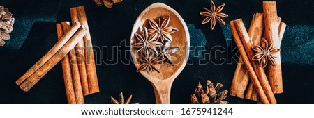 wooden spoon with star anise, cinnamon sticks, cones, christmas spices background, ingredients for wine