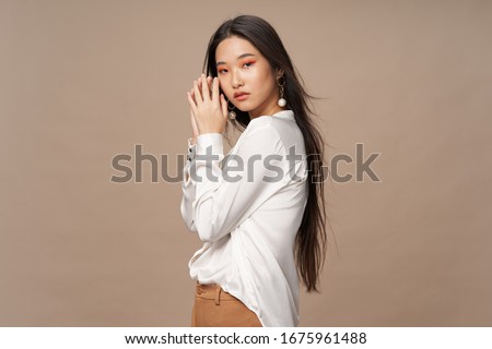 Beige background white shirt beautiful woman dark hair Royalty-Free Stock Photo #1675961488