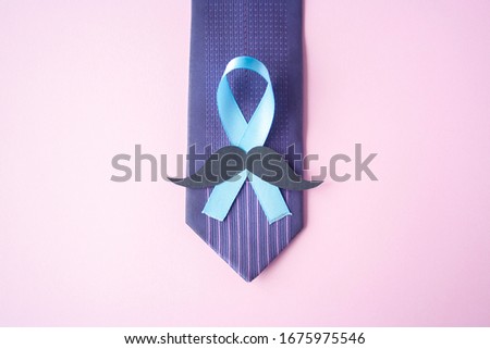 Prostate Cancer Awareness, light Blue Ribbon with mustache on blue men tie for support people living and illness. Men Healthcare and World cancer day concept. Men carcinoma health symbol
