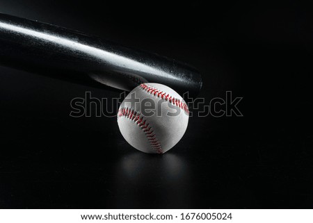 Baseball game equipment on dark black background close up
