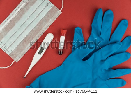 Medical surgical doctor mask, flu and corona virus protection isolated with electronic thermometer and doctor hands in gloves on red background. Health care concept. Copy space for text.