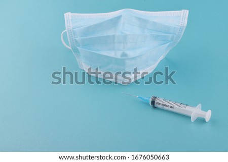 Coronavirus and Air pollution pm2.5 concept.Mask and syringe on blue background