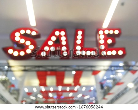 Abstract blur background of red wording light bulb SALE at shopping department store. 