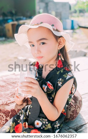 Lovely asian girl drinking a glass of milk
