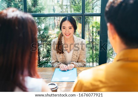 Cheerful asian HR woman interviewing two candiates at meeting room.
