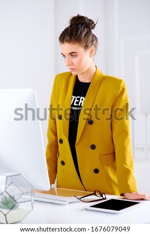 Young female designer in the office works at the computer. Businesswoman in the office