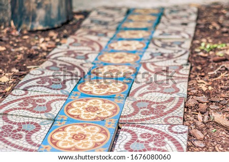 Mosaic decorated floor bricks making a row
