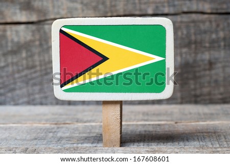 Guyana Flag on Small wooden framed blackboard on wooden background