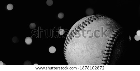 Close up of used baseball ball with bokeh lights background.