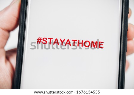 CORONAVIRUS STAYATHOME HASHTAG ON SMARTPHONE SCREEN Royalty-Free Stock Photo #1676134555