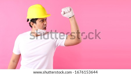Asian man Industry worker or engineer working an architect builder Happy excited raising his fists  on pink background in studio With copy space,concept international labour day.