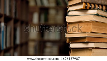 The stack ancient books on a library background Royalty-Free Stock Photo #1676167987