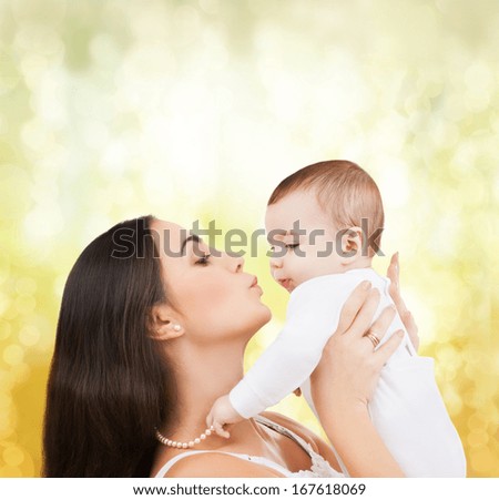 family, children, parenthood and happiness concept - happy mother kissing her child